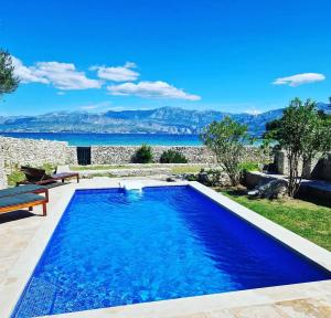 a swimming pool with a view of the water at Vila Lovrečina in Postira