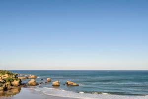 a view of a beach with rocks and the ocean at Hôtel Le Windsor Biarritz in Biarritz