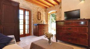 a living room with a television and a dresser at Vila Lovrečina in Postira