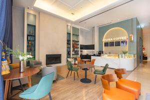 a lobby with tables and chairs and a coffee shop at Miramar Garden Taipei in Taipei