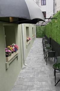 a patio with tables and chairs and an umbrella at Sawei Urban Hotel in Craiova
