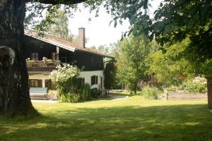 a house in a park with a tree at Bauernhaus auf dem Land in Hebertsfelden