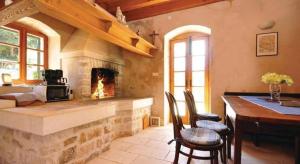a living room with a fireplace and a table and chairs at Vila Lovrečina in Postira