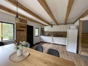 a kitchen and dining room with a table and a refrigerator at Cranberry Cabin Buscat in Muntele Băişorii +4 photos