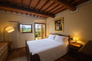 a bedroom with a large white bed and a window at Borgo Sette Tigli in Montepulciano +62 photos