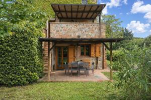 a stone house with a table and chairs in a yard at Borgo Sette Tigli in Montepulciano