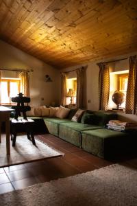 a living room with a green couch and a table at Bauernhaus auf dem Land in Hebertsfelden