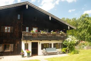 a large wooden house with a balcony at Bauernhaus auf dem Land in Hebertsfelden +7 photos