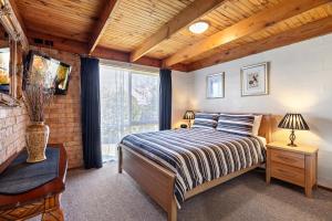 a bedroom with a bed and a large window at Bungunyah Apartments in Croydon