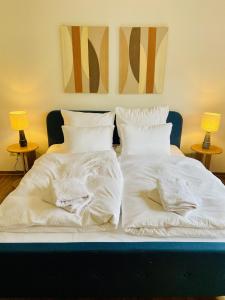 two beds with white sheets and pillows on them at Landhaus Mira in Witzenhausen