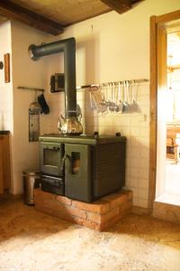 an old stove in a kitchen with a wall at Bauernhaus auf dem Land in Hebertsfelden