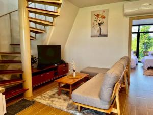 a living room with a couch and a television at ฟูจิจันท์ fujijun cafe&resort in Ban Na Khieo