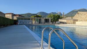 a swimming pool with two metal rails next to a building at Oustal de Bourdeaux in Bourdeaux