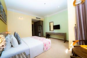 a hotel room with a bed and a desk at HIG Hotel & Convention in Kuah