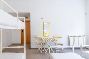 a room with a bed and a table and chairs at Hi Espinho - Pousada de Juventude in Espinho +40 photos