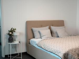 a bedroom with a bed and a table with a lamp at Comfort Apartment Midami in Schwanau