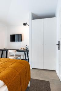 a bedroom with a bed and a desk and a tv at Seta Hotel in Bellagio