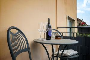 a table with wine glasses and wine bottles on a balcony at Pompeii Central Home in Pompei