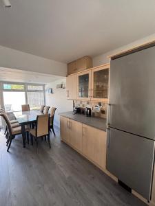 a kitchen with a table and a stainless steel refrigerator at Craigport Cottage in Portrush