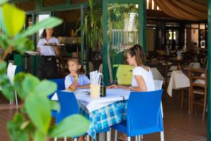a woman and child sitting at a table in a restaurant at Holiday Park Spiaggia e Mare in Porto Garibaldi