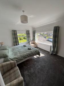 a bedroom with a bed and a couch and a window at Craigport Cottage in Portrush +17 photos