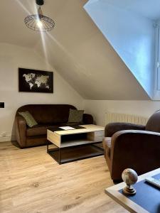 a living room with a couch and a table at Le Studio du Square : Châteaux-Beauval-Arrivée auto-Netflix in Romorantin +9 photos
