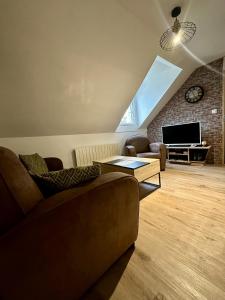 a living room with a couch and a television at Le Studio du Square : Châteaux-Beauval-Arrivée auto-Netflix in Romorantin