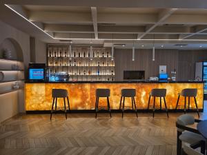 a bar in a hotel with four bar stools at Hotel IN in Žepče