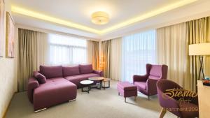 a living room with a purple couch and chairs at Hotel Siesta in Užice