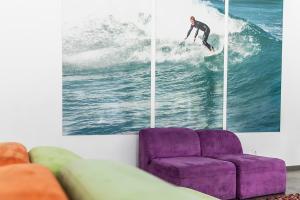 a man riding a wave on a surfboard in the ocean at Hi Espinho - Pousada de Juventude in Espinho