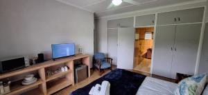 a living room with a bed and a flat screen tv at Drakensberg Rest in Kimberley