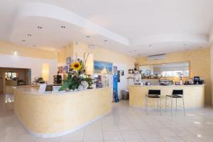 a lobby with a counter with stools and a kitchen at Villa Silvie Rose in Cesenatico