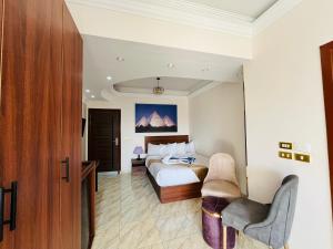 a hotel room with a bed and a chair at Marquis Pyramids Hotel in Cairo