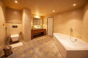 a bathroom with a tub and a toilet and a sink at Pride Premier Darjeeling in Darjeeling +45 photos