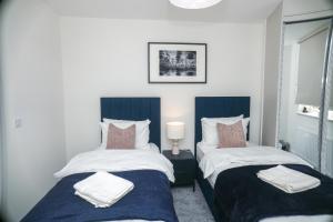 two beds sitting next to each other in a bedroom at Little Haven Thames view Free Parking Closer to Heathrow in Staines