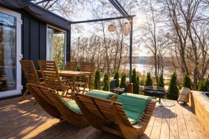 a patio with a table and chairs on a deck at Wisla66 Domki nad Wisłą Piotrawin in Piotrawin