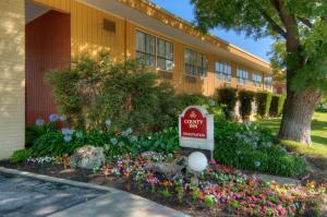 a sign in front of a building with flowers at County Inn in Mountain View
