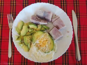 a plate of breakfast food with eggs meat and vegetables at Avocado Lodge in Lushoto