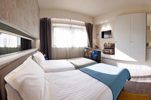 AlbavillaにあるAlbavilla Hotel & Coのベッド2台と窓が備わるホテルルームです。