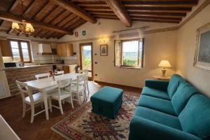 a living room with a blue couch and a table at Borgo Sette Tigli in Montepulciano
