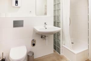 a white bathroom with a sink and a toilet at Zentrale Monteurwohnung in Oldenburg i H in Oldenburg in Holstein