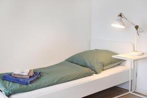 a bed with a green pillow and a table at Zentrale Monteurwohnung in Oldenburg i H in Oldenburg in Holstein
