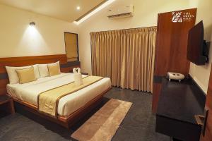 a hotel room with a bed and a television at The Green Hive Villas in Belgaum +25 photos