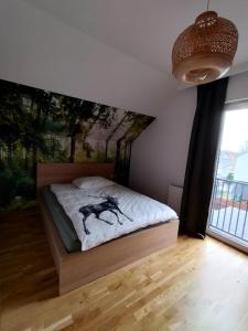 a bedroom with a bed with a painting on the wall at Chata na Psiaku in Wrocław