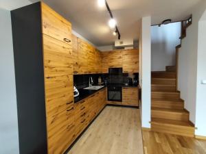 a kitchen with wooden walls and a staircase at Chata na Psiaku in Wrocław