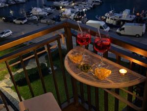 two glasses of red wine on a table on a balcony at Little Medieval House Nettuno in Nettuno +11 photos