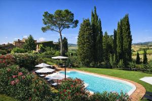 a swimming pool in a garden with umbrellas at Borgo Sette Tigli in Montepulciano