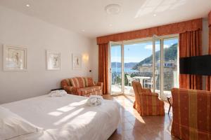 a hotel room with a bed and a large window at LVG Hotel Collection - Grand Hotel Mediterranee in Alassio
