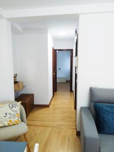 a living room with a couch and a wooden floor at LA CASINA DE HUGO AZUL centro Luanco in Luanco +11 photos