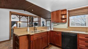 a kitchen with wooden cabinets and a black dishwasher at Victory View in Gettysburg
